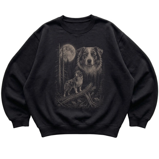 Australian Shepherd Moonlit Forest graphic on a black crewneck sweatshirt laid flat