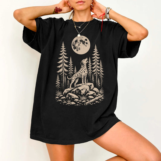 Model wearing a Black Comfort Colors® T-shirt with a Dalmatian howling beneath the moon and pine trees