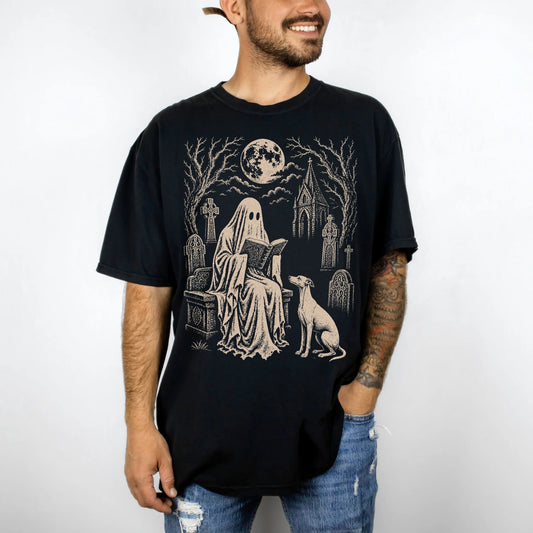 Model wearing a Black Comfort Colors® T-shirt showing Whippet beside a reading ghost in a moonlit graveyard