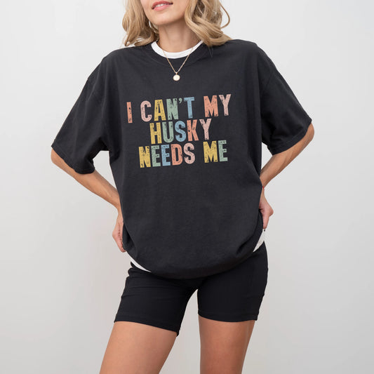 Model wearing a Black Comfort Colors® T-shirt featuring Husky with “I Can’t, My Dog Needs Me” lettering