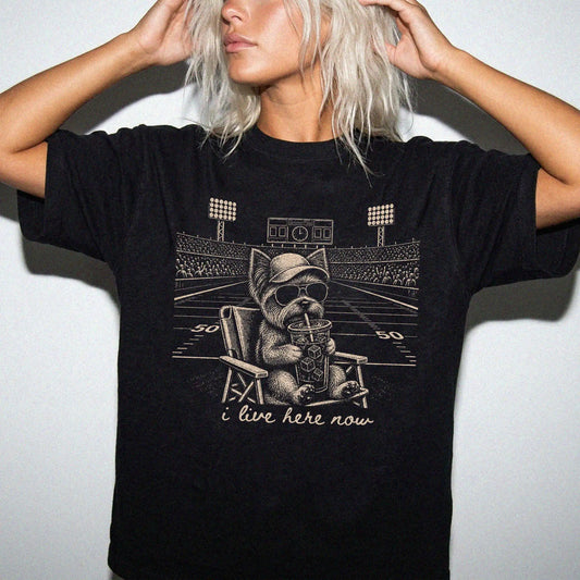 Model wearing a Black Comfort Colors® T-shirt featuring Yorkie claiming the football field with “I Live Here Now” lettering