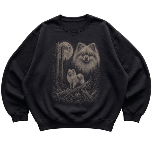 Pomeranian Moonlit Forest graphic on a black crewneck sweatshirt laid flat