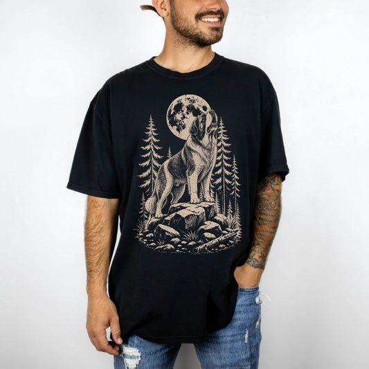 Model wearing a Black Comfort Colors® T-shirt with a Saint Bernard howling beneath the moon and pine trees