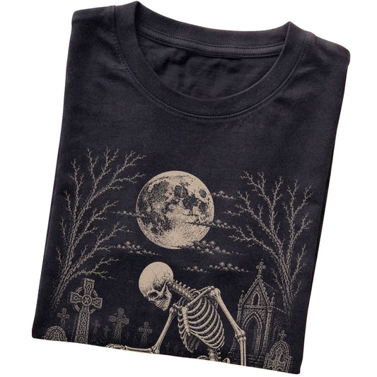 Folded Black T-shirt with a skeleton petting a Poodle in a graveyard