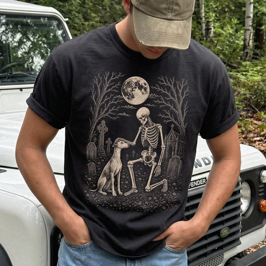Model wearing a Black Comfort Colors® T-shirt showing Whippet sharing a quiet cemetery moment with a friendly skeleton