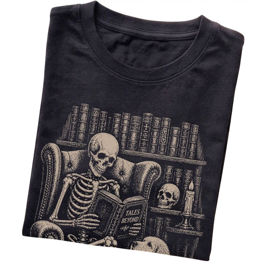 Folded Black T-shirt with a skeleton reading Tales Beyond to a Labradoodle