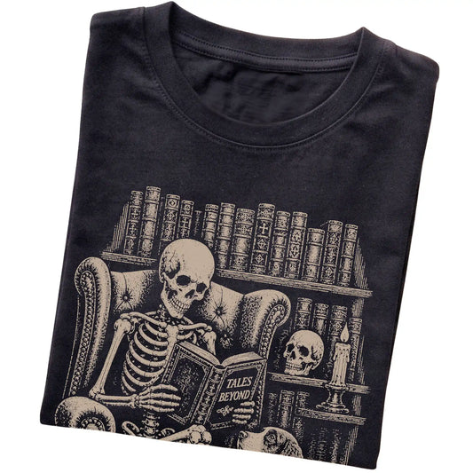 Folded Black T-shirt with a skeleton reading Tales Beyond to a Springer Spaniel