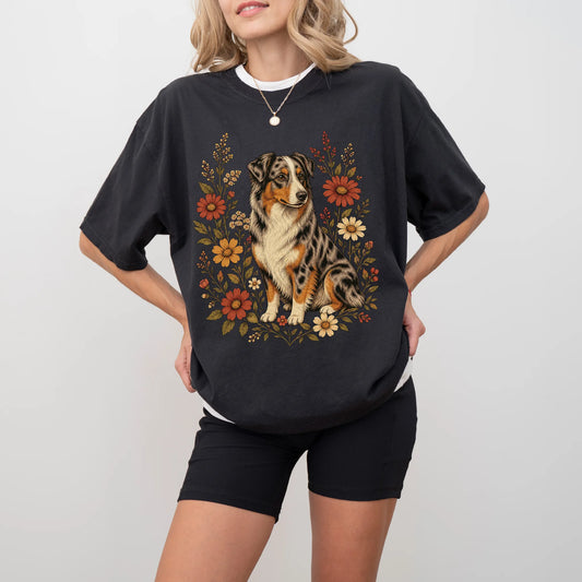 Model wearing a Black Comfort Colors® T-shirt showing Australian Shepherd portrait surrounded by wildflowers beneath the moon