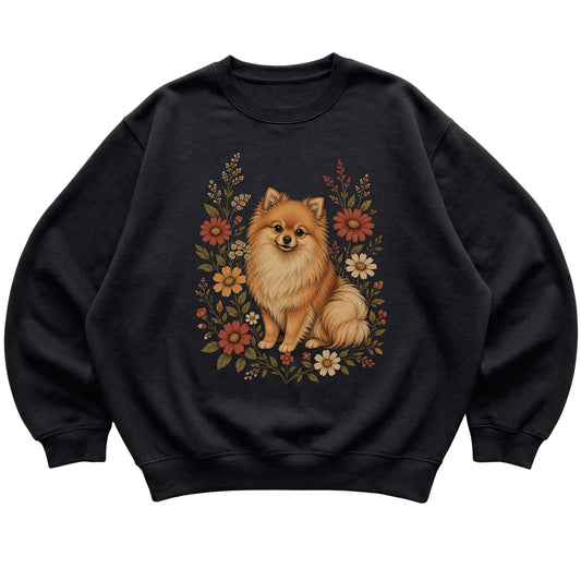 Black crewneck sweatshirt with Pomeranian portrait and wildflowers, flat lay