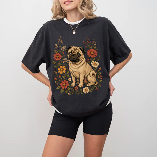 Model wearing a Black Comfort Colors® T-shirt showing Pug portrait surrounded by wildflowers beneath the moon