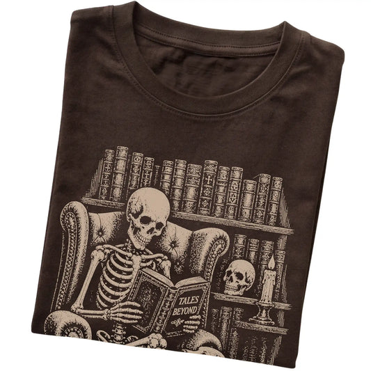 Folded Dark Chocolate T-shirt with a skeleton reading Tales Beyond to a Beagle