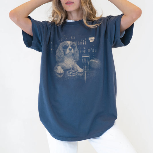 Model wearing a Denim Comfort Colors® T-shirt featuring Cavalier King Charles Spaniel with beer and football graphics