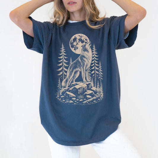 Model wearing a Denim Comfort Colors® T-shirt with a Collie howling beneath the moon and pine trees