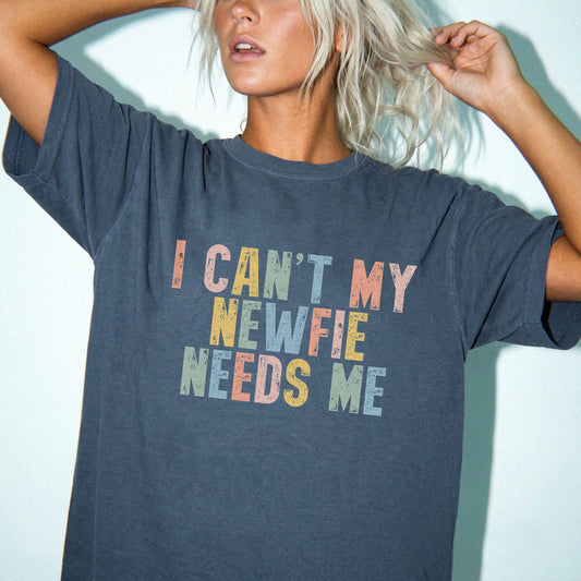 Model wearing a Denim Comfort Colors® T-shirt featuring Newfie with “I Can’t, My Dog Needs Me” lettering