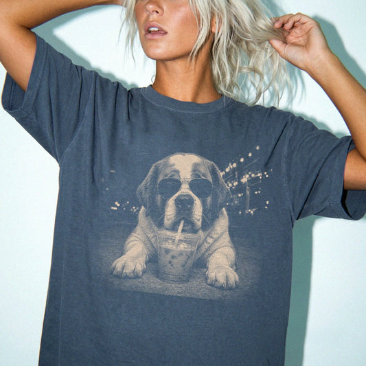 Model wearing a Denim Comfort Colors® T-shirt featuring Saint Bernard with iced coffee in a retro grunge design