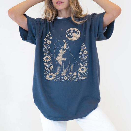 Model wearing a Denim Comfort Colors® T-shirt featuring Bernese Mountain Dog framed by flowers beneath the moon