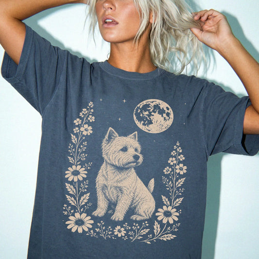 Model wearing a Denim Comfort Colors® T-shirt featuring Westie framed by flowers beneath the moon