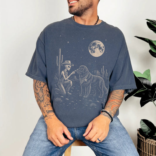 Model wearing a Denim Comfort Colors® T-shirt with cowboy alien fist-bumping a newfie beneath the moon