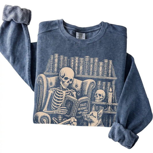 Folded Denim sweatshirt with a skeleton reading Tales Beyond to a German Shepherd