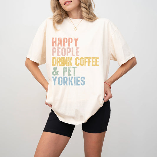 Model wearing a Ivory Comfort Colors® T-shirt featuring Yorkie with coffee and “Happy People Drink Coffee and Pet Dogs” lette