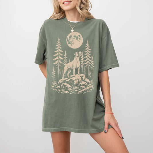 Model wearing a Moss Comfort Colors® T-shirt with a Boxer howling beneath the moon and pine trees