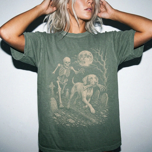 Model wearing a Moss Comfort Colors® T-shirt showing Vizsla running through a moonlit graveyard with a chasing skeleton