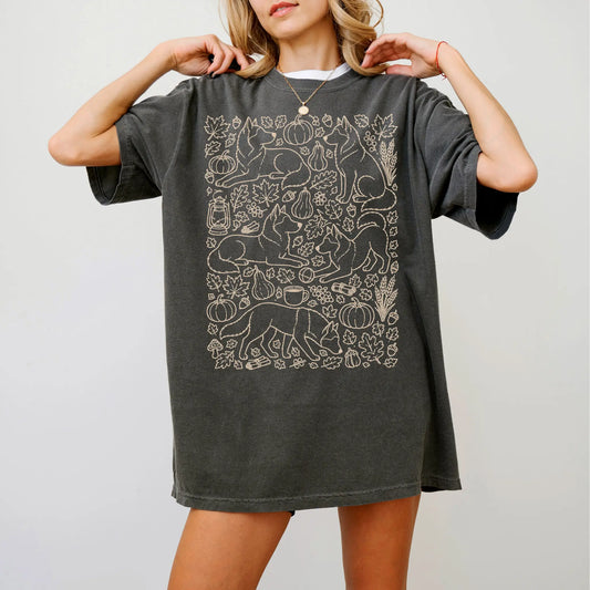 Model wearing a Pepper Comfort Colors® T-shirt with Husky dogs with pumpkins, leaves, acorns, and woodland details