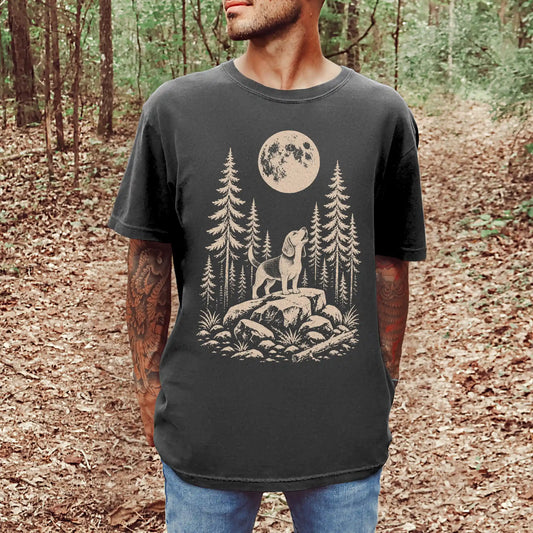 Model wearing a Pepper Comfort Colors® T-shirt with a Beagle howling beneath the moon and pine trees