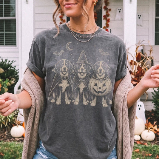 Model wearing a Pepper Comfort Colors® T-shirt showing three Bernese Mountain Dog dogs dressed for Halloween beneath bats and