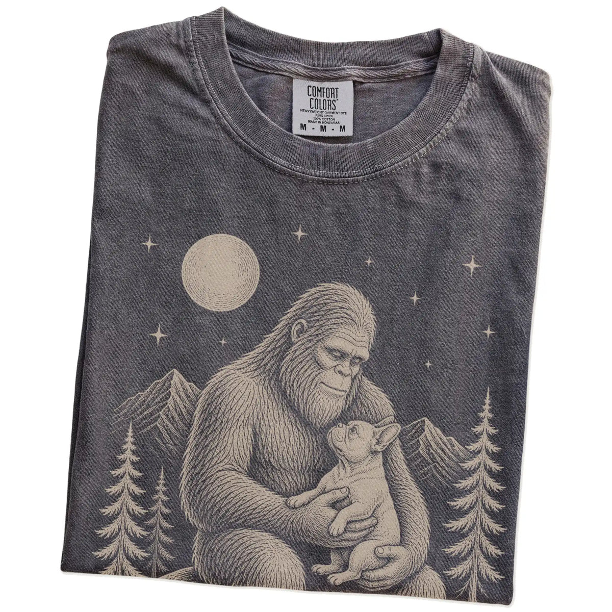 Folded Pepper Comfort Colors® T-shirt showing Bigfoot holding a French Bulldog