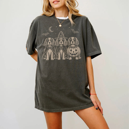 Model wearing a Pepper Comfort Colors® T-shirt showing three Cavalier King Charles Spaniel dogs dressed for Halloween beneath