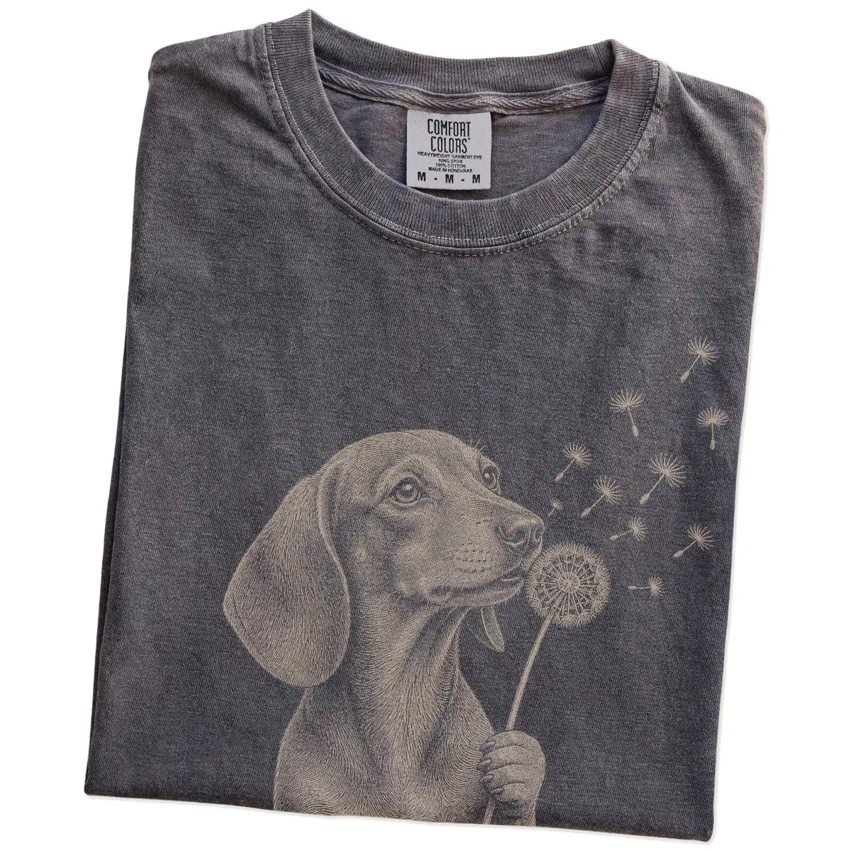 Folded Pepper Comfort Colors® T-shirt showing Dachshund portrait with drifting dandelion seeds