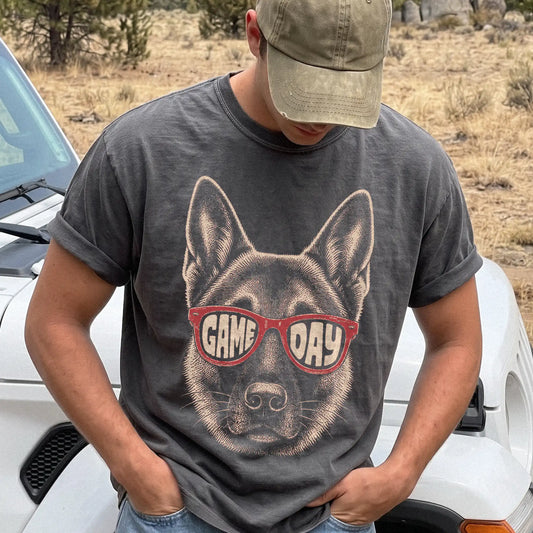Model wearing a Pepper Comfort Colors® T-shirt with german shepherd wearing red game day sunglasses