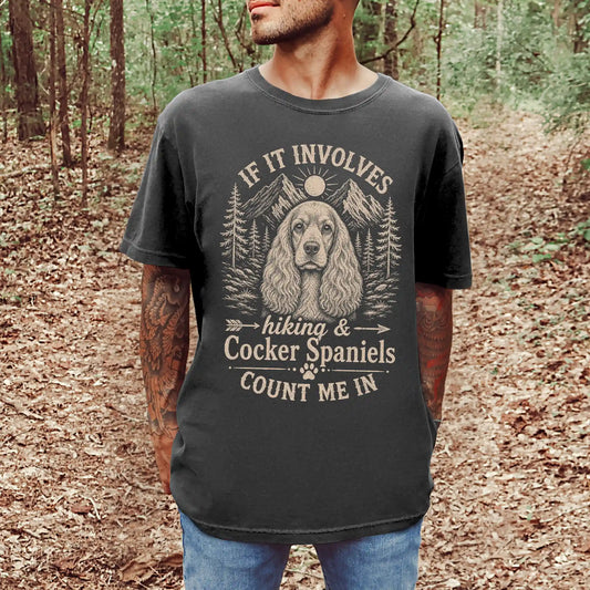 Model wearing a Pepper Comfort Colors® T-shirt featuring Cocker Spaniel hiking design with mountain scenery