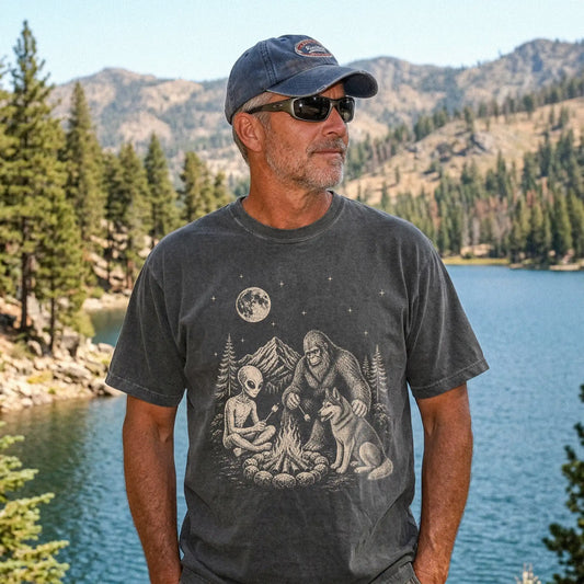 Model wearing a Pepper Comfort Colors® T-shirt showing Husky camping with Bigfoot and an alien