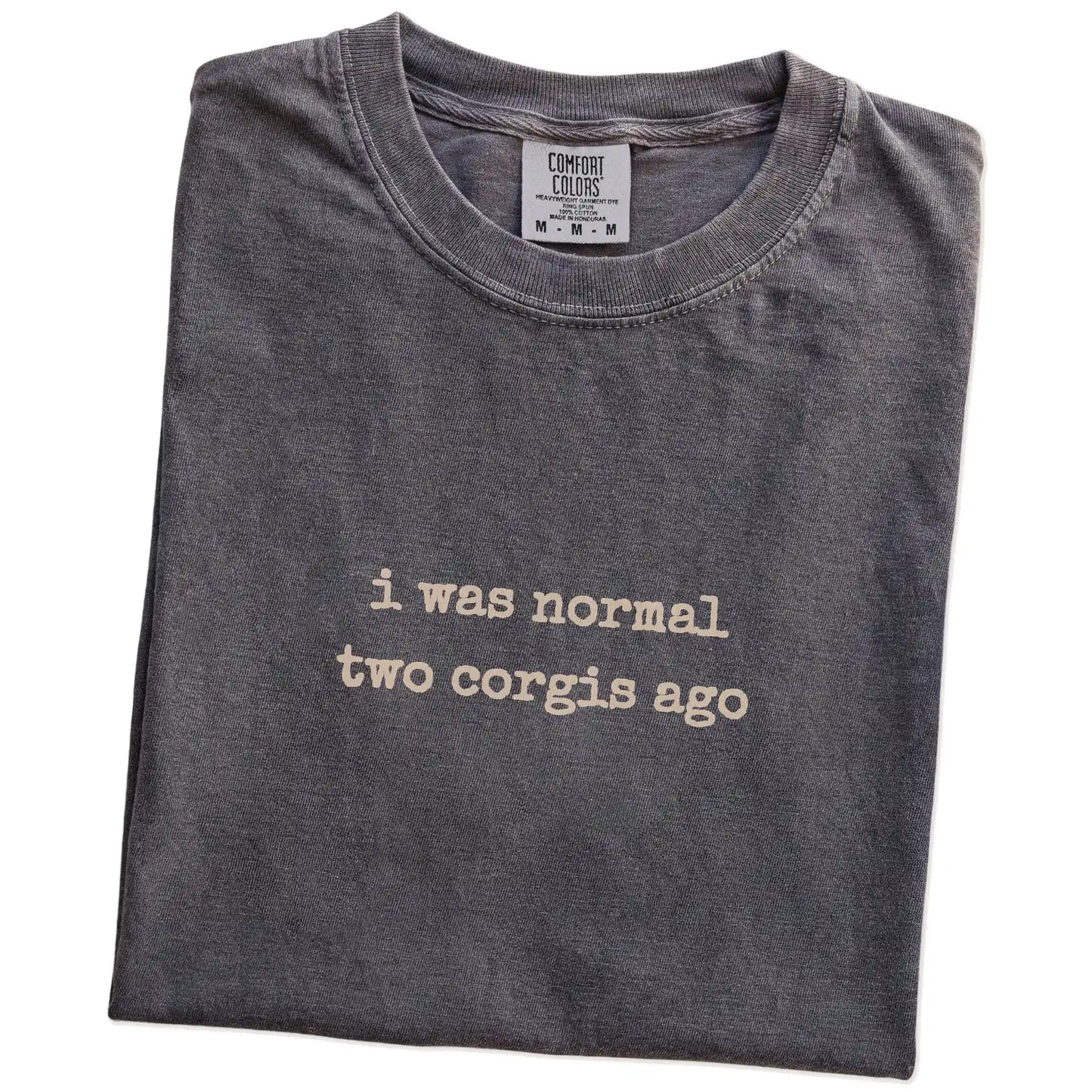 Folded Pepper Comfort Colors® T-shirt showing i was normal two corgis ago lettering