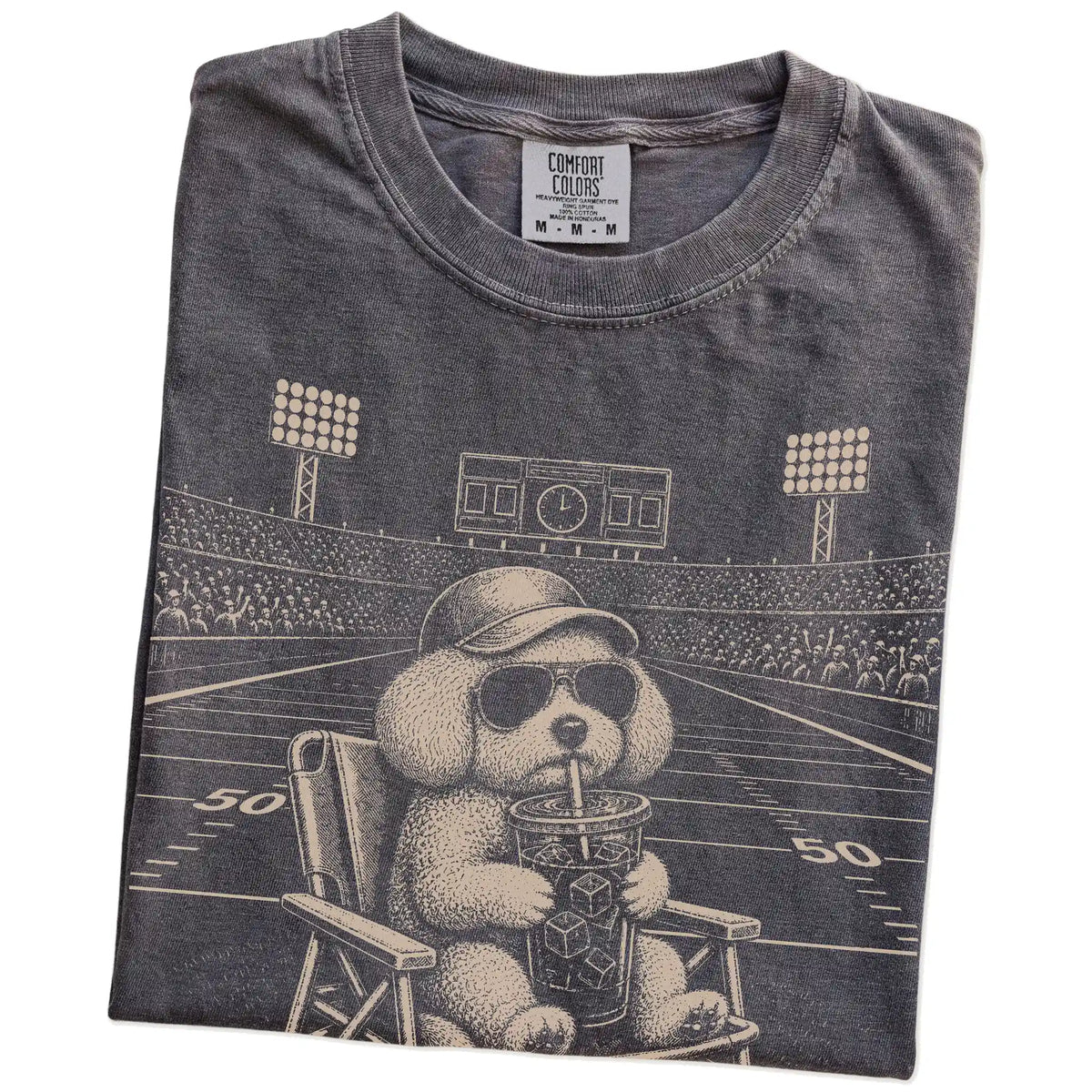 Folded Pepper Comfort Colors® T-shirt showing Bichon Frise claiming the football field with “I Live Here Now” lettering