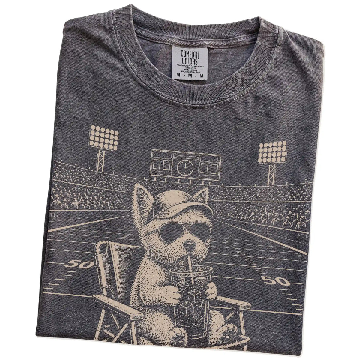Folded Pepper Comfort Colors® T-shirt showing Westie claiming the football field with “I Live Here Now” lettering
