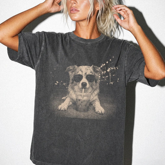 Model wearing a Pepper Comfort Colors® T-shirt featuring Australian Shepherd with iced coffee in a retro grunge design