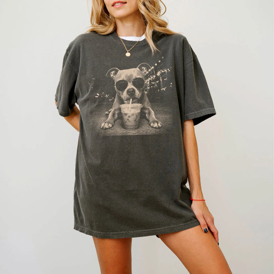 Model wearing a Pepper Comfort Colors® T-shirt featuring Pitbull with iced coffee in a retro grunge design