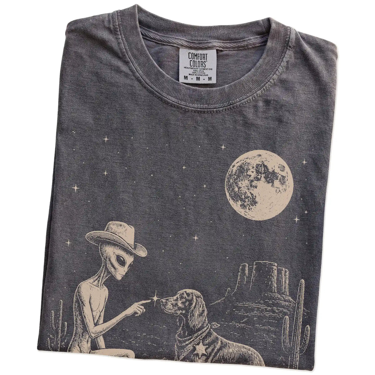 Folded Pepper Comfort Colors® T-shirt showing cowboy alien fist-bumping a irish setter beneath the moon