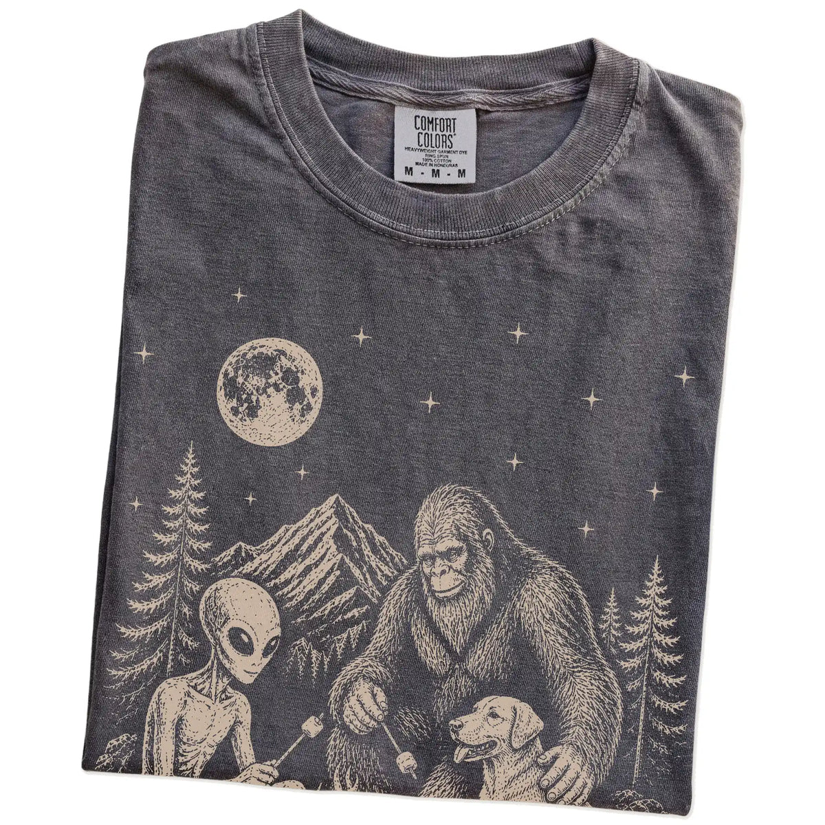 Folded Pepper Comfort Colors® T-shirt showing Labrador Retriever camping with Bigfoot and an alien