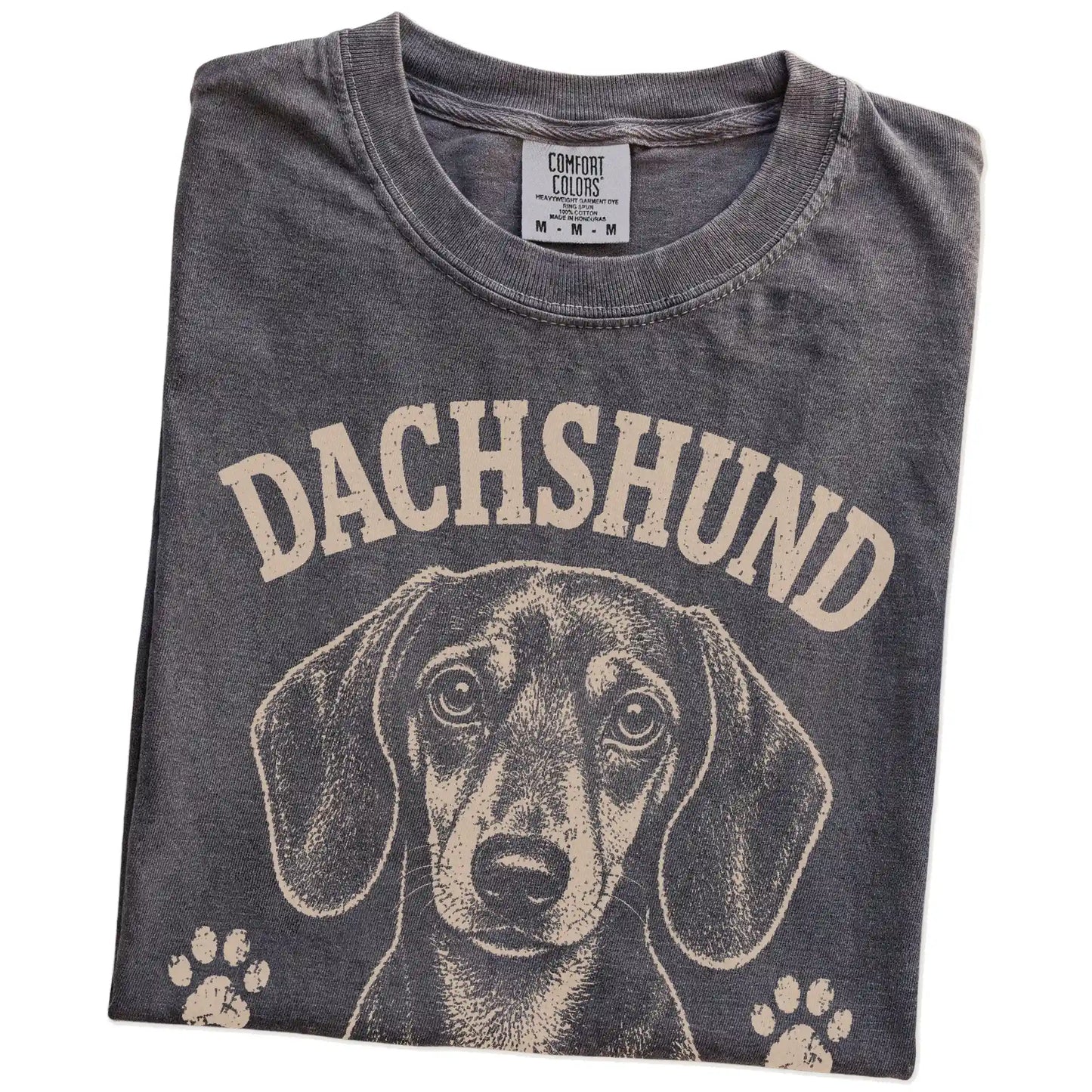 Folded Pepper Comfort Colors® T-shirt showing Dachshund design with “Long Story Short, I'm Stubborn” lettering