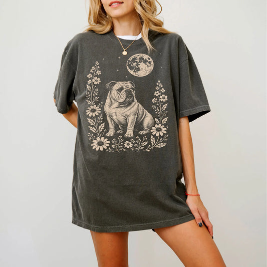 Model wearing a Pepper Comfort Colors® T-shirt featuring Bulldog framed by flowers beneath the moon