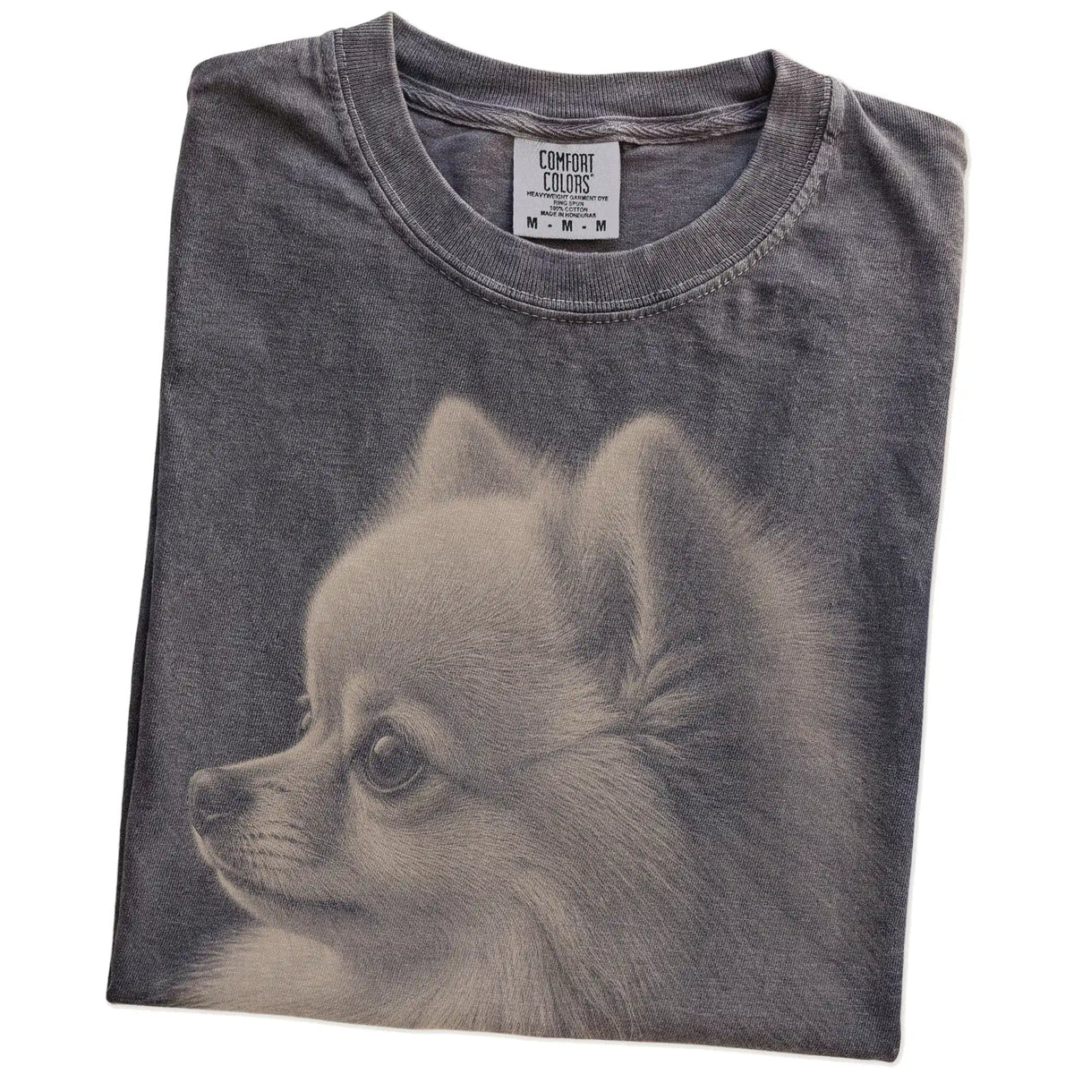 Folded Pepper Comfort Colors® T-shirt showing a detailed photographic portrait of a Pomeranian