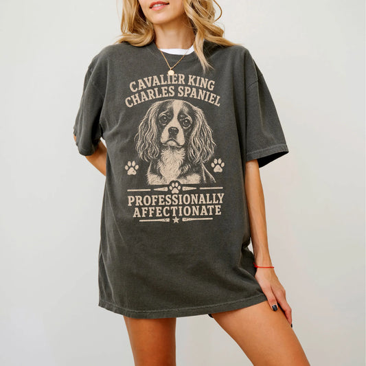 Model wearing a Pepper Comfort Colors® T-shirt featuring Cavalier King Charles Spaniel design with “Professionally Affectiona