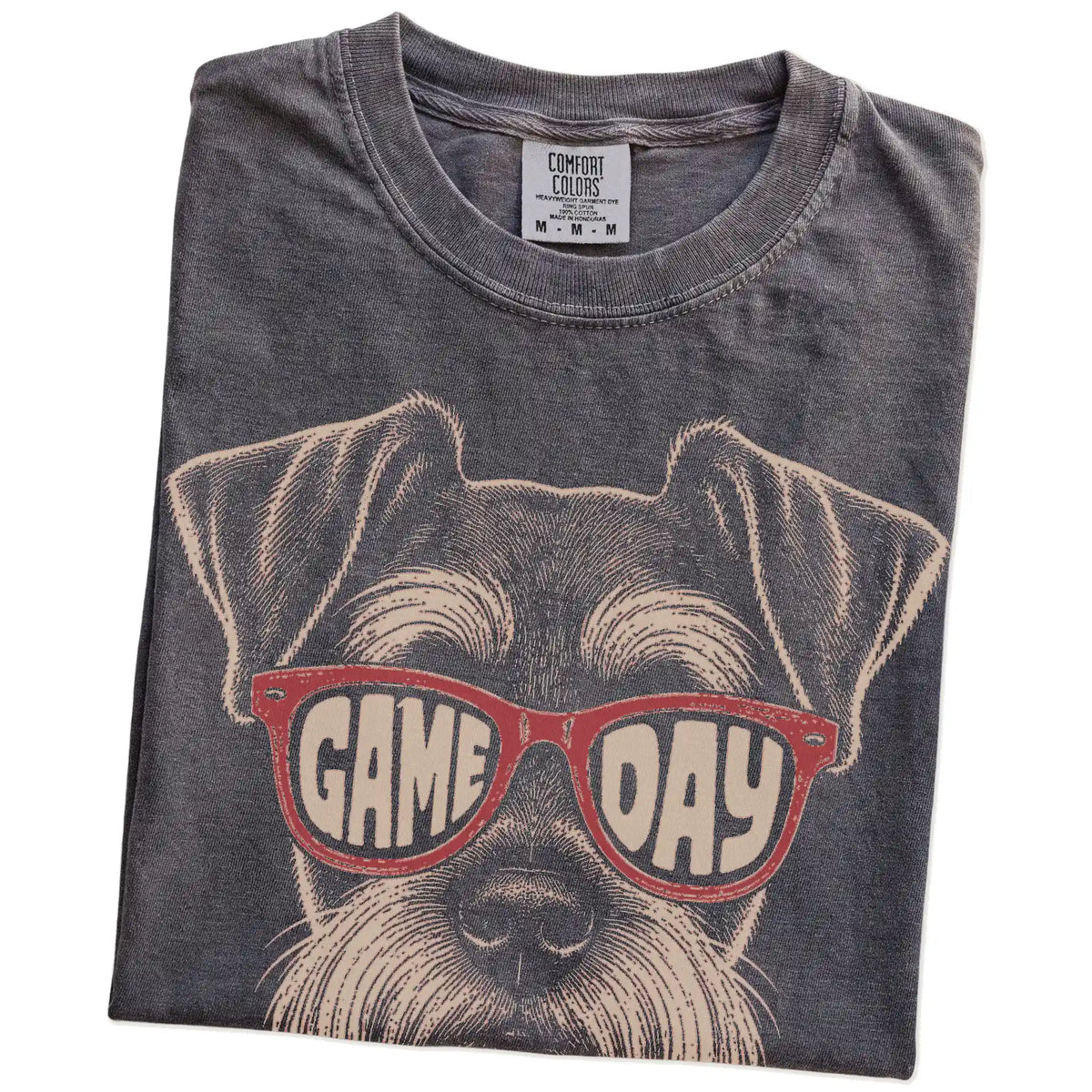 Folded Pepper Comfort Colors® T-shirt showing schnauzer wearing red game day sunglasses