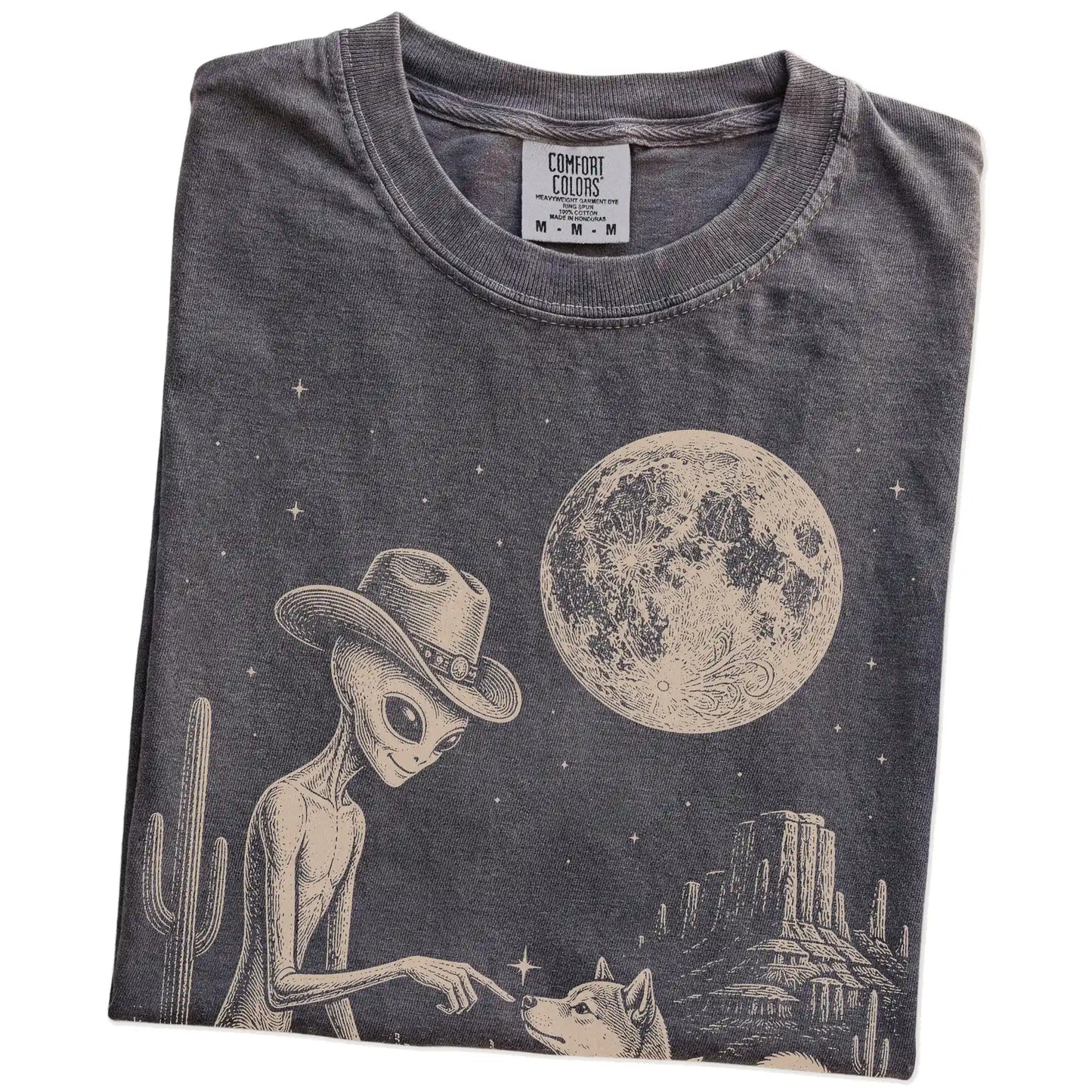 Folded Pepper Comfort Colors® T-shirt showing cowboy alien fist-bumping a shiba inu beneath the moon