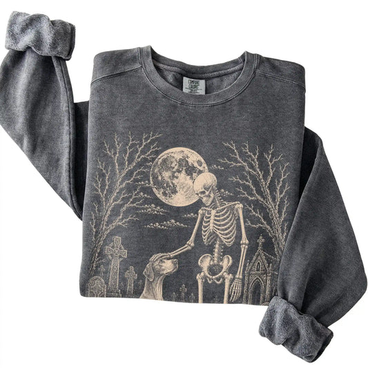 Folded Pepper sweatshirt with a skeleton petting a Pointer in a graveyard