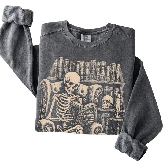 Folded Pepper sweatshirt with a skeleton reading Tales Beyond to a Basset Hound